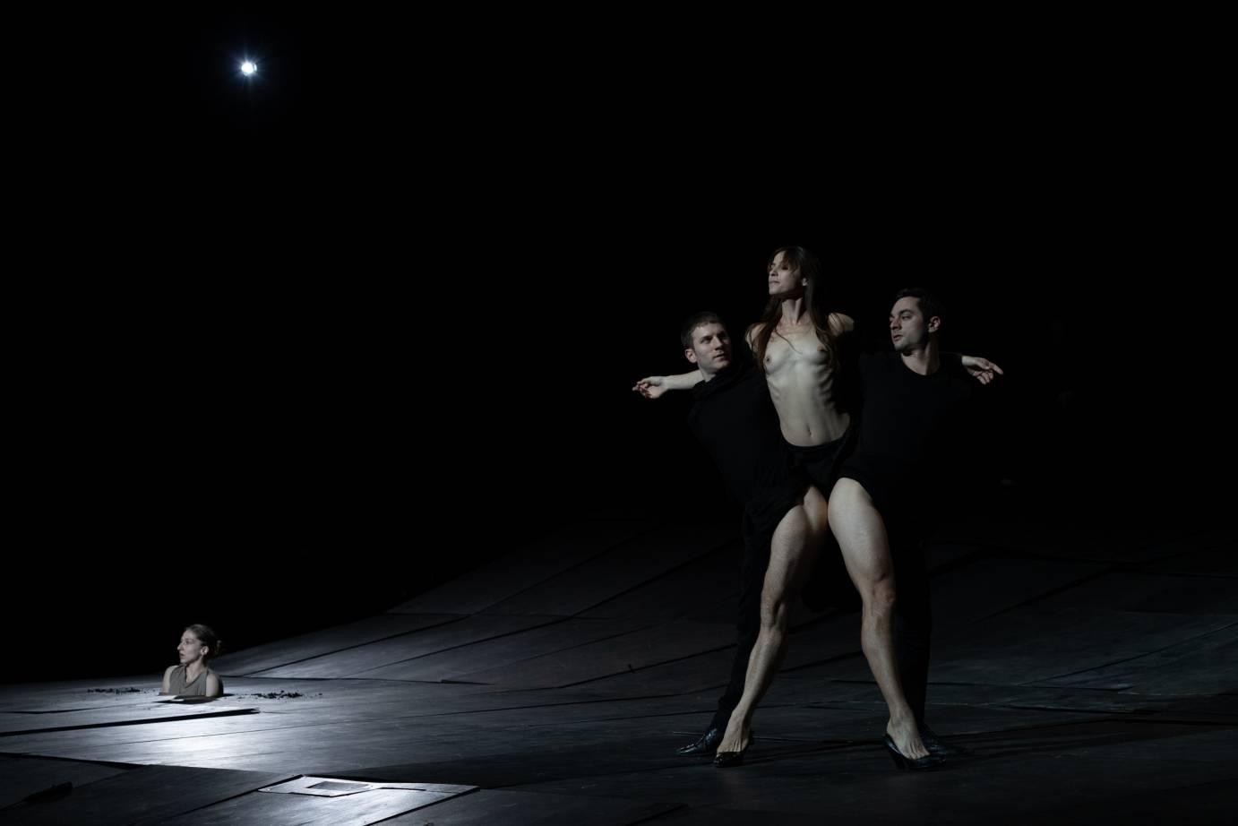 Three performers use bare limbs to form a lewd pose
